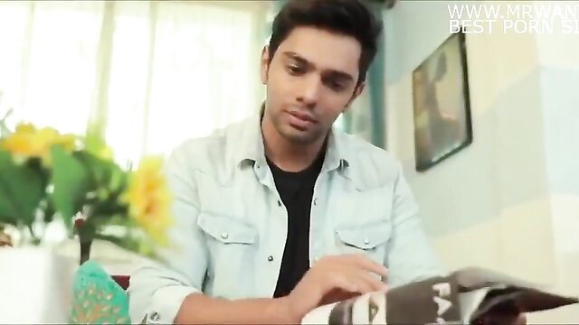 Handsome young Indian man in white shirt reading magazine at table