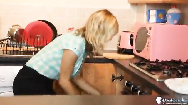 Busty blonde British babe bending over kitchen counter in blouse