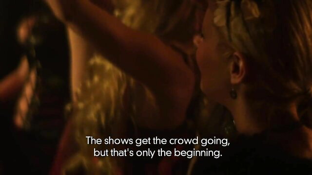 Blonde woman in sexy dress dances on stage, crowd cheers