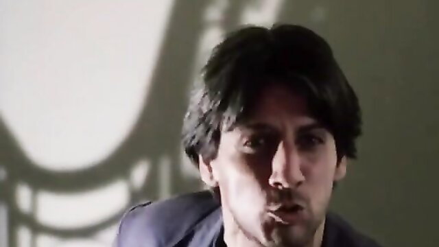 Vintage man with sharp features smirking in dim light