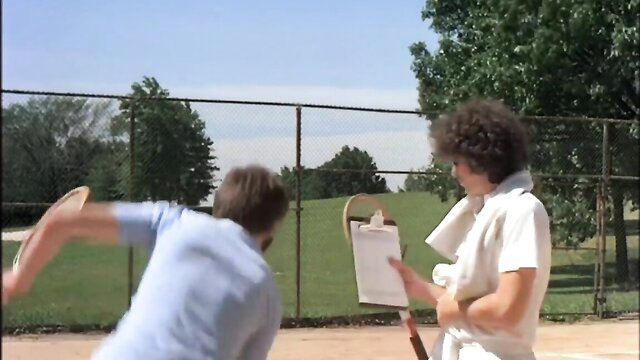 Vintage tennis couple in action on court, athletic man and curly-haired woman