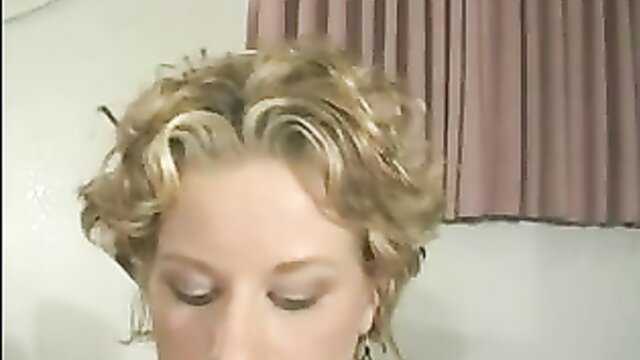 Closeup of mature blonde woman with curly hair, seductive eyes