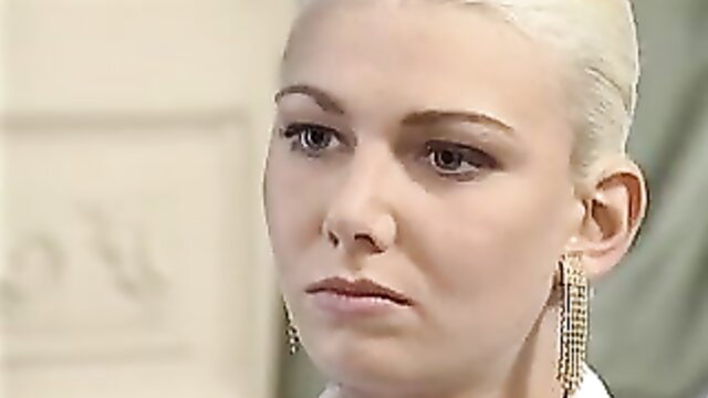 Blonde woman with sultry gaze and dangling earrings in closeup