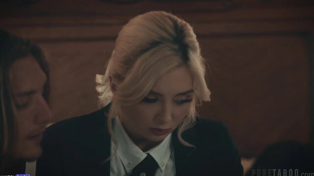 Lexi Lore in sultry black suit and tie, intense courtroom stare