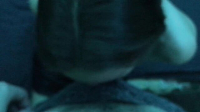 Blurry closeup of petite babe's head and shoulders in dim teal light