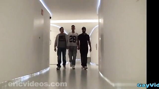 Three hot athletic guys in sportswear walking hallway threesome preview