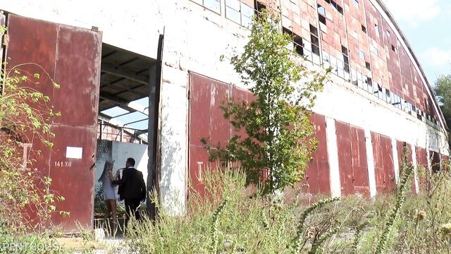 Gina Gerson outside abandoned building in short dress